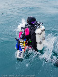 Diver with twinset cylinders jumps into the sea