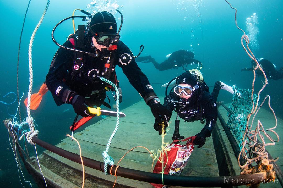 Two divers practice cutting rope
